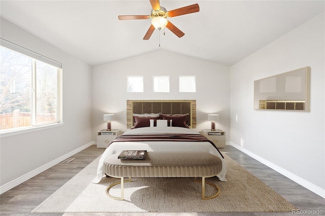 bedroom featuring ceiling fan, baseboards, vaulted ceiling, and wood finished floors