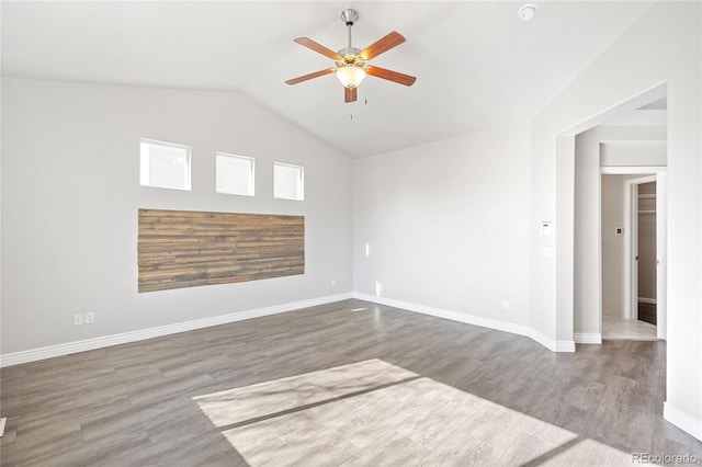 spare room featuring lofted ceiling, a ceiling fan, baseboards, and wood finished floors