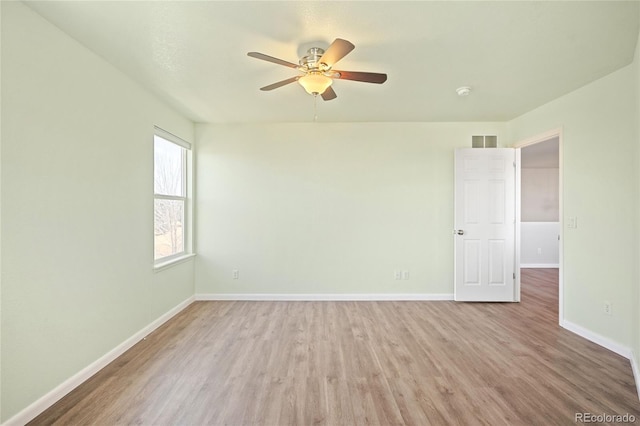 empty room featuring baseboards, visible vents, ceiling fan, and wood finished floors