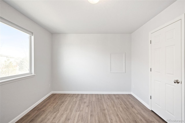 spare room with light wood-style flooring and baseboards