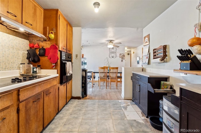 kitchen featuring backsplash, light tile patterned floors, black appliances, and ceiling fan