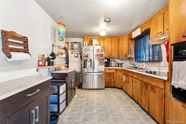 kitchen featuring tasteful backsplash, sink, black appliances, and light tile patterned flooring