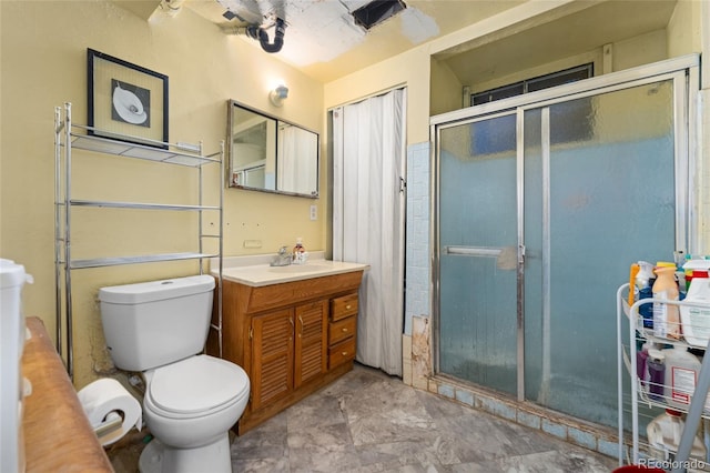 bathroom with a shower with door, vanity, and toilet