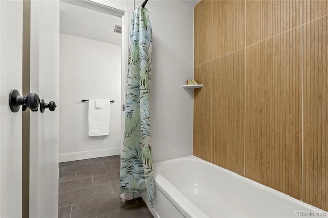 bathroom featuring tile patterned floors, baseboards, and shower / tub combo