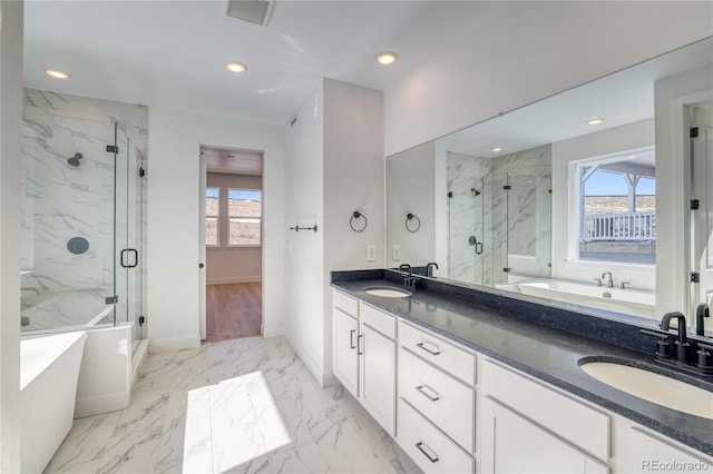 bathroom with a sink, visible vents, marble finish floor, and a freestanding tub