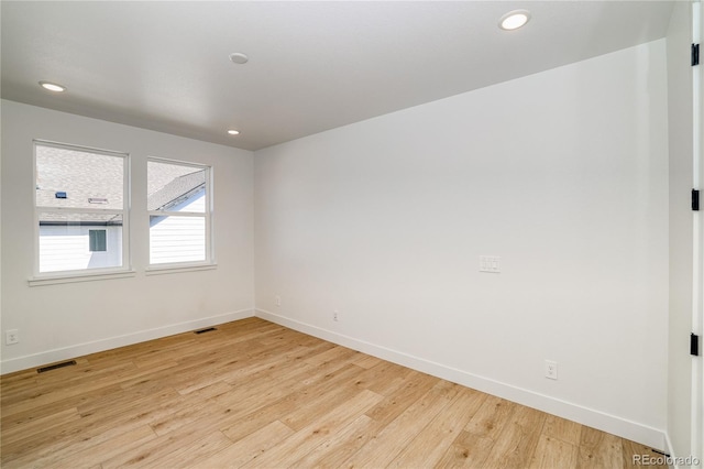 spare room featuring visible vents, recessed lighting, baseboards, and light wood-style floors