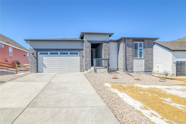 view of front of home featuring stone siding, concrete driveway, an attached garage, and fence