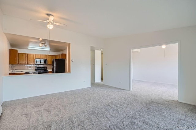 unfurnished living room with light carpet, ceiling fan, and a sink