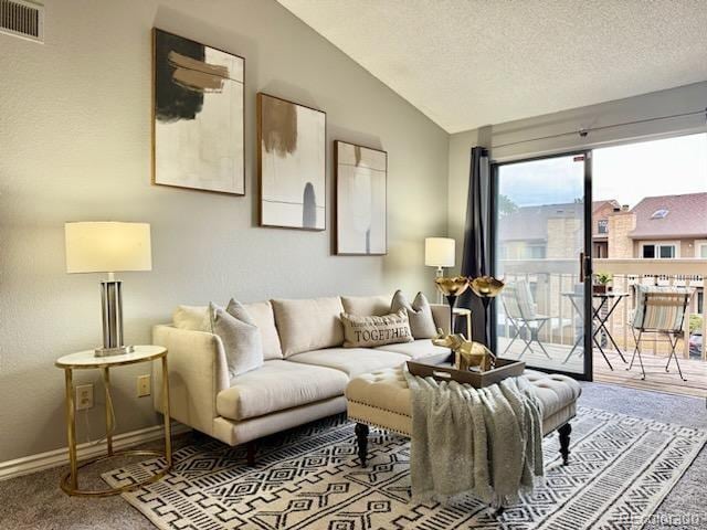 carpeted living room with lofted ceiling, a textured ceiling, visible vents, and baseboards