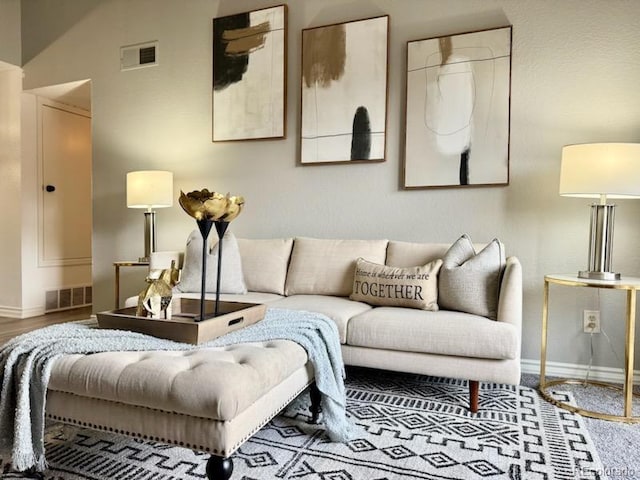 living room with visible vents, baseboards, and wood finished floors