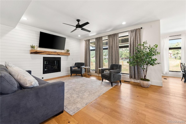 living room with ceiling fan and light wood-type flooring