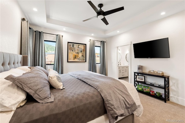 carpeted bedroom featuring ceiling fan, connected bathroom, and a raised ceiling