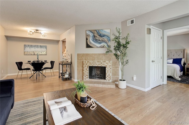 3550 S Harlan St Unit 259, Denver, CO 80235 - living room with a fireplace, wood finished floors, a textured ceiling, and baseboards