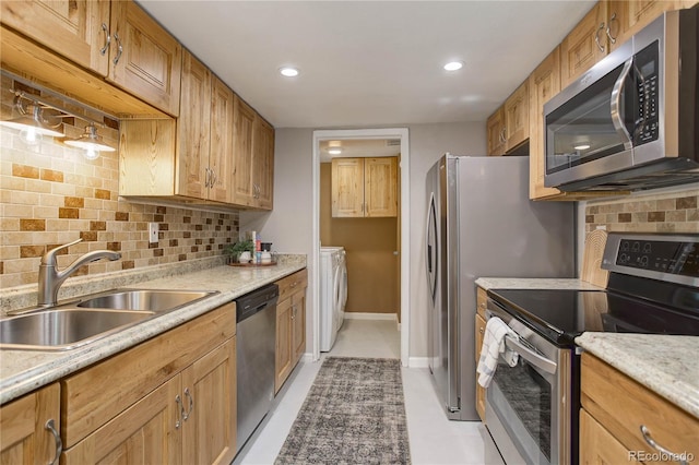 3550 S Harlan St Unit 259, Denver, CO 80235 - kitchen with appliances with stainless steel finishes, decorative backsplash, a sink, washer and dryer, and recessed lighting