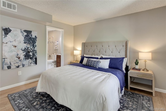 3550 S Harlan St Unit 259, Denver, CO 80235 - bedroom featuring wood finished floors, baseboards, a textured ceiling, and connected bathroom
