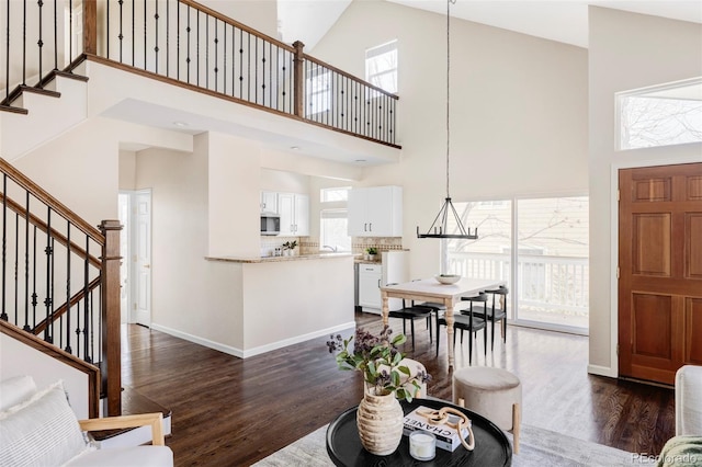 living room with dark wood-style floors, plenty of natural light, and stairs