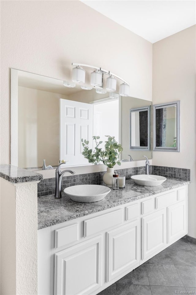 full bathroom with double vanity, tile patterned flooring, and a sink