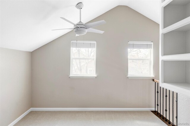 additional living space featuring vaulted ceiling, carpet flooring, and plenty of natural light