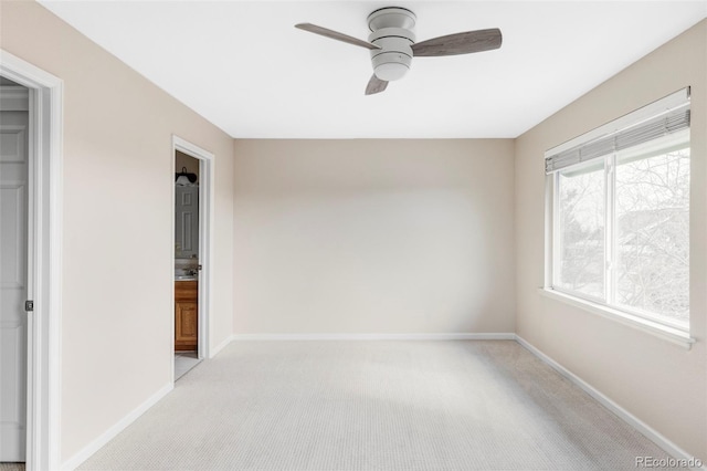 unfurnished room with baseboards, a ceiling fan, and light colored carpet