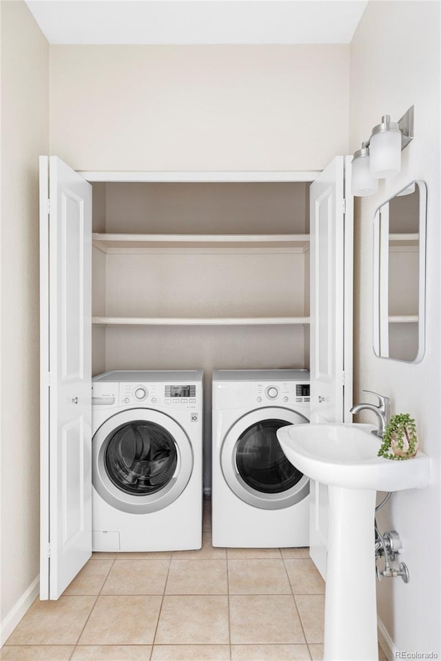 laundry room featuring light tile patterned floors, laundry area, and independent washer and dryer