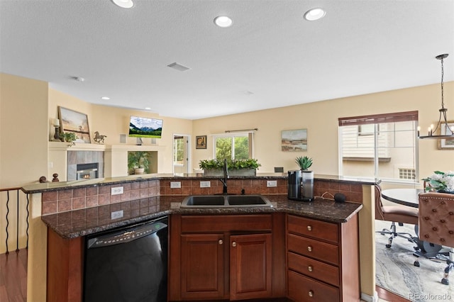 6542 S Tempe St, Aurora, CO 80016 - kitchen with black dishwasher, open floor plan, dark stone countertops, a chandelier, and pendant lighting