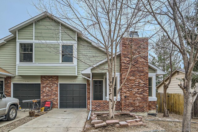 view of front facade with concrete driveway, fence, an attached garage, brick siding, and a chimney
