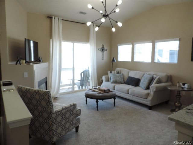 carpeted living room with vaulted ceiling, a tile fireplace, a chandelier, and a healthy amount of sunlight