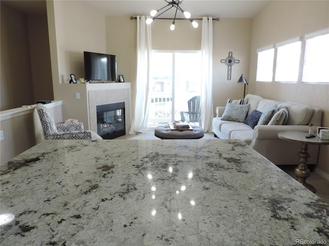 living room with a chandelier and a tile fireplace