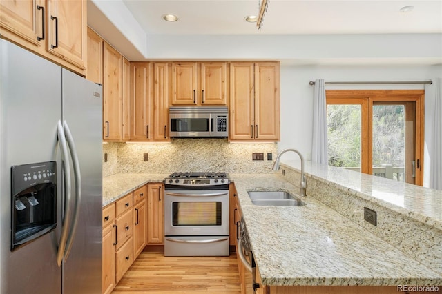 101 Lions Ln, Minturn, CO 81645 - kitchen featuring stainless steel appliances, a sink, a peninsula, light stone counters, and backsplash