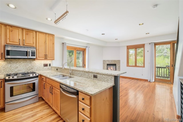 101 Lions Ln, Minturn, CO 81645 - kitchen with stainless steel appliances, a sink, a peninsula, light wood-style floors, and recessed lighting