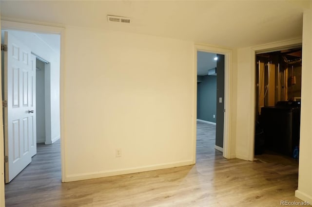 unfurnished room featuring washer / dryer and light wood-type flooring