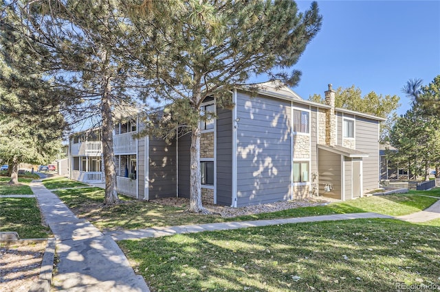 view of front of home with a balcony and a front yard