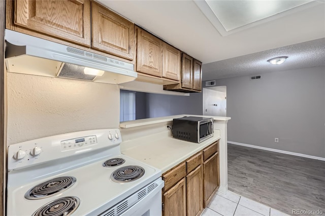 kitchen with white range with electric stovetop, light wood-type flooring, and a textured ceiling