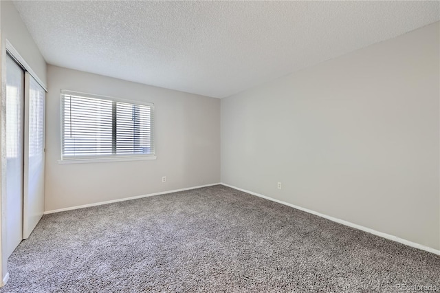 carpeted spare room featuring a textured ceiling