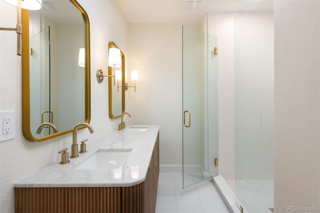 bathroom with a shower with shower door, vanity, and tile patterned flooring