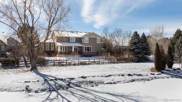 view of snow covered rear of property