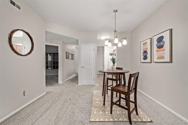 dining area featuring a notable chandelier, light colored carpet, visible vents, and baseboards