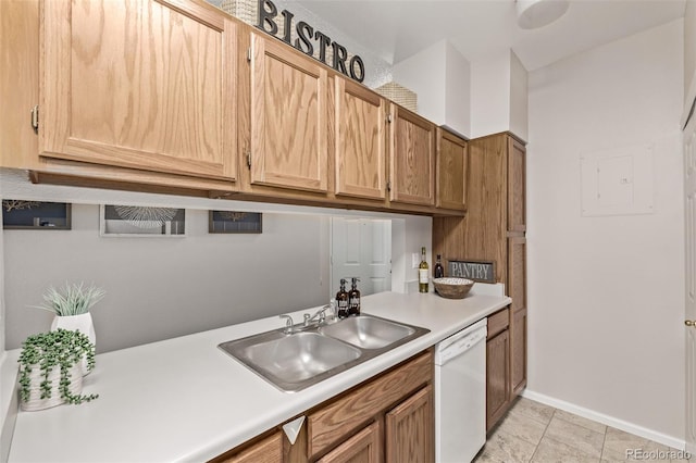 kitchen with a sink, light countertops, light tile patterned floors, baseboards, and dishwasher