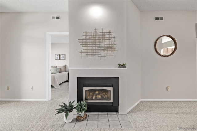 interior details with visible vents, a fireplace with flush hearth, carpet, and a textured ceiling