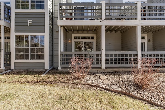 view of exterior entry with a balcony and covered porch