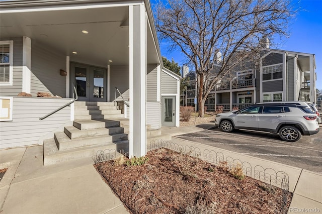 view of side of property featuring french doors and uncovered parking