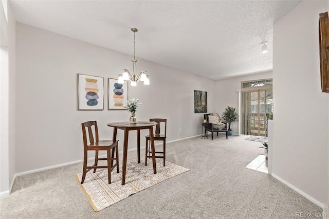 dining space with baseboards, an inviting chandelier, a textured ceiling, and carpet