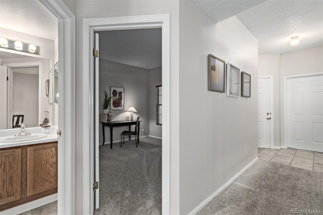 7481 Singing Hills Dr, Boulder, CO 80301 - corridor featuring light colored carpet, a textured ceiling, a desk, and light tile patterned floors