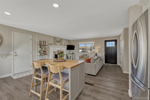 280 Jupiter Dr, Lone Tree, CO 80124 - kitchen featuring freestanding refrigerator, butcher block countertops, a kitchen breakfast bar, light wood-style floors, and recessed lighting