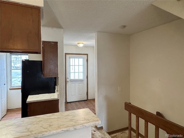 kitchen with a textured ceiling and light hardwood / wood-style flooring