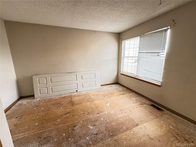 unfurnished room featuring a textured ceiling