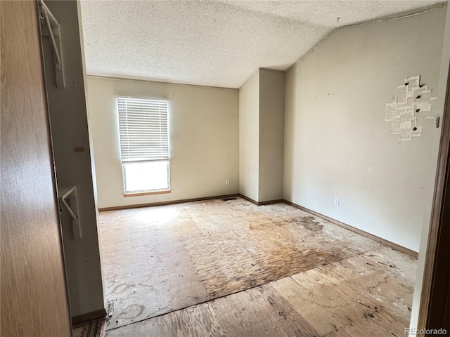 spare room with vaulted ceiling and a textured ceiling