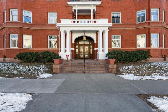 snow covered property entrance featuring french doors