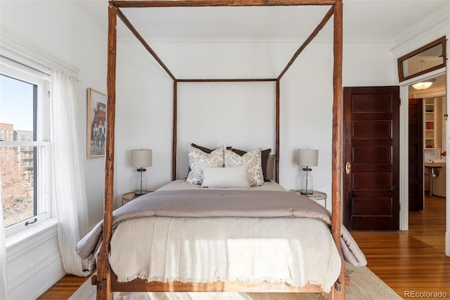 bedroom featuring hardwood / wood-style flooring and crown molding