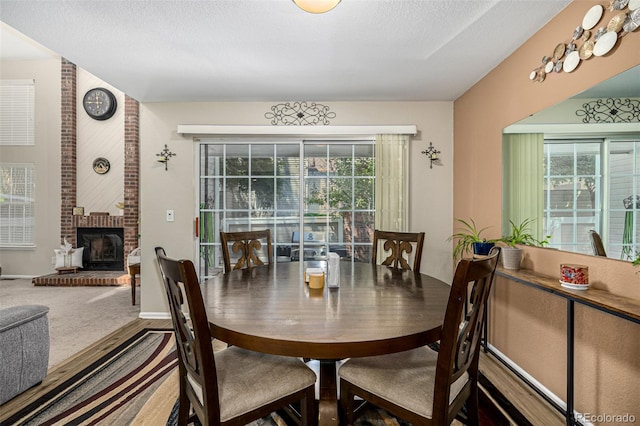 7684 S Monaco Cir, Centennial, CO 80112 - dining room featuring a fireplace, a textured ceiling, and carpet floors